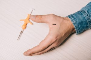 Imagen de microchip para humanos sobre mano con jeringa de inserccion